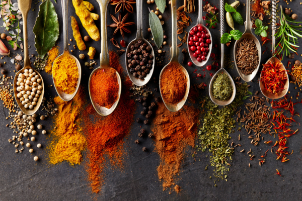 Several different spices on spoons.